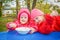 Two little girls, in red jackets, sit at a table and eat pasta.