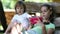 Two little girls with red smartphone sits on swing bench