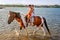 Two little girls riding horse in the summer in Ada Bojana, Monte