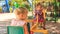 two little girls rock on swing on play ground in tropical park