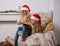 Two little girls in Santa caps are reading a book