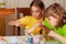 Two little girls (sisters) painting on Easter eggs