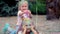 Two little girls sisters, a teenage girl and a little one lie on the lawn, play and sprinkle with colored sand in a park