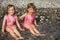 Two little girls sit ashore in water