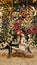 two little girls sit on a swing against a wall of flowers.