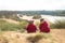 Two little girls are sitting on top of a sand dune