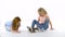 Two little girls is stroking fluffy Sheltie guinea pig at white background. Slow motion.