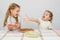 Two little girls at a table prepared pizza