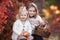 Two little girls walk outdoors in the Park during the Golden autumn