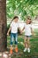 Two little girls in white t-shirts jumping in park outdoor.