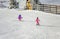 Two Little girsl skiing fast downhill