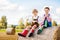 Two little kid boy and girl in traditional Bavarian costumes in wheat field. German children sitting on hay bale during
