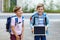 Two little kid boys with backpack or satchel. Schoolkids on the way to school. Healthy children, brothers and best