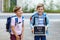 Two little kid boys with backpack or satchel. Schoolkids on the way to school. Healthy children, brothers and best