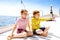 Two little kid boys, best friends enjoying sailing boat trip. Family vacations on ocean or sea on sunny day. Children