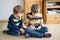 Two little kid boys reading a book at home