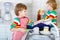 Two little kid boys washing dishes in domestic kitchen