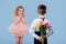 Two little kids boy with flowers and surprised girl in pink dres