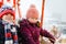 Two little kids, boy and girl having fun on ferris wheel on traditional German Christmas market during strong snowfall