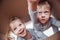 Two a little kids boy and girl opening a cardboard box and climbing in the middle of it. Children have fun