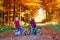 Two little kids boys, best friends in autumn forest with bikes. Active siblings, children with bicycles. Boys in