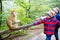 Two little kids boys in colorful clothes feeding monkey