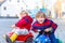 Two little kids boys in colorful clothes and rain boots driving toy cars. Siblings making competition, outdoors. Active