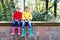 Two little kids boys, cute siblings in colorful rain boots. Close-up of children in different rubber boots and jackets