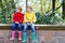 Two little kids boys, cute siblings in colorful rain boots. Close-up of children in different rubber boots and jackets