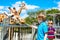 Two little kids boys and father watching and feeding giraffe in