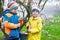 Two little kids boys and friends making traditional Easter egg hunt