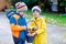 Two little kids boys and friends making traditional Easter egg hunt