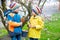 Two little kids boys and friends making traditional Easter egg hunt