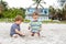 Two little kids boys having fun with building sand castle on tropical beach