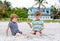 Two little kids boys having fun with building sand castle on tropical beach, happy best friends playing. Siblings