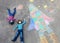Two little kids boys having fun with drawing universe and space shuttle picture with colorful chalks. Creative leisure