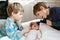 Two little kids boys playing with newborn baby sister girl