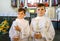 Two little kids boys receiving his first holy communion. Happy children holding Christening candle. Tradition in