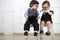 Two little kids in glasses sitting on white chairs