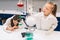 Two little kids in lab coat learning chemistry in school laboratory. Young scientists in protective glasses making