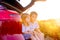 Two little kids peeks out of the car in the sunset.Summer travel
