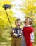 Two little kids taking selfie in park in autumn