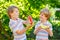 Two little preschool kid boys with blond hairs eating red and yellow watermelon in summer garden. Funny happy children