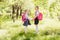 Two little Schoolgirls in school uniform stand with backpacks and hold hands outdoors