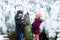 Two little siblings kid boy and girl holding christmas tree. Happy children in winter clothes choosing and buying xmas