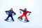 Two little siblings kid boys in colorful winter clothes making snow angel, laying down on snow.