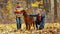 Two little sister girls play in the autumn Park with an Irish setter dog