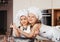 Two little sisters cuddle in the kitchen in white chef hats. Hilarious girlfriends play in the kitchen