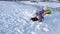 Two little sisters fall on the snow and have fun