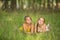 Two little sisters lying in the meadow looking at the camera. Nature.